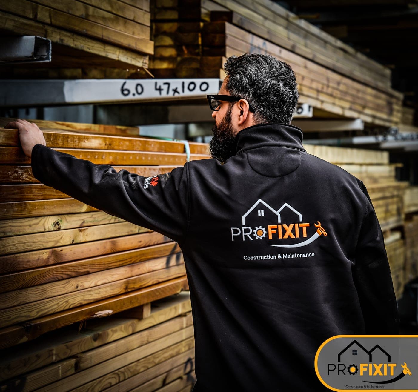 A worker selecting timber from a tall rack.